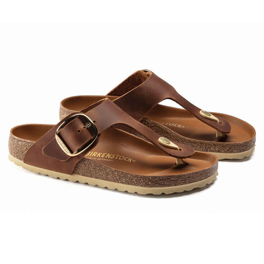 Brown Birkenstock thong sandals with adjustable buckle and cork sole