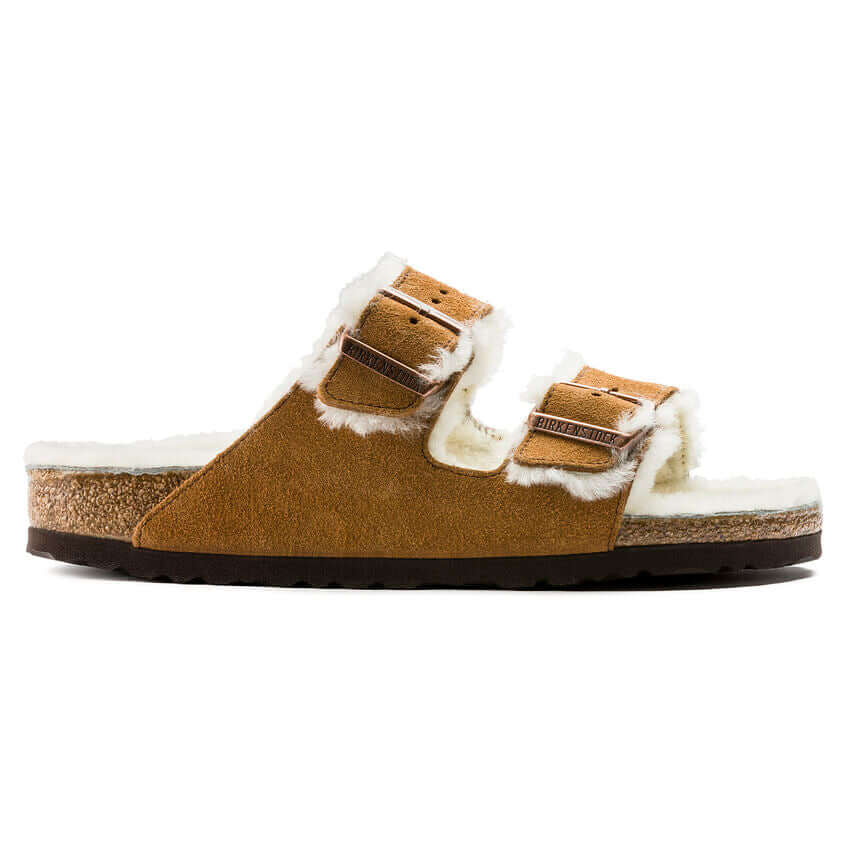 Tan suede Birkenstock Arizona sandals with shearling lining and double buckle straps on white background