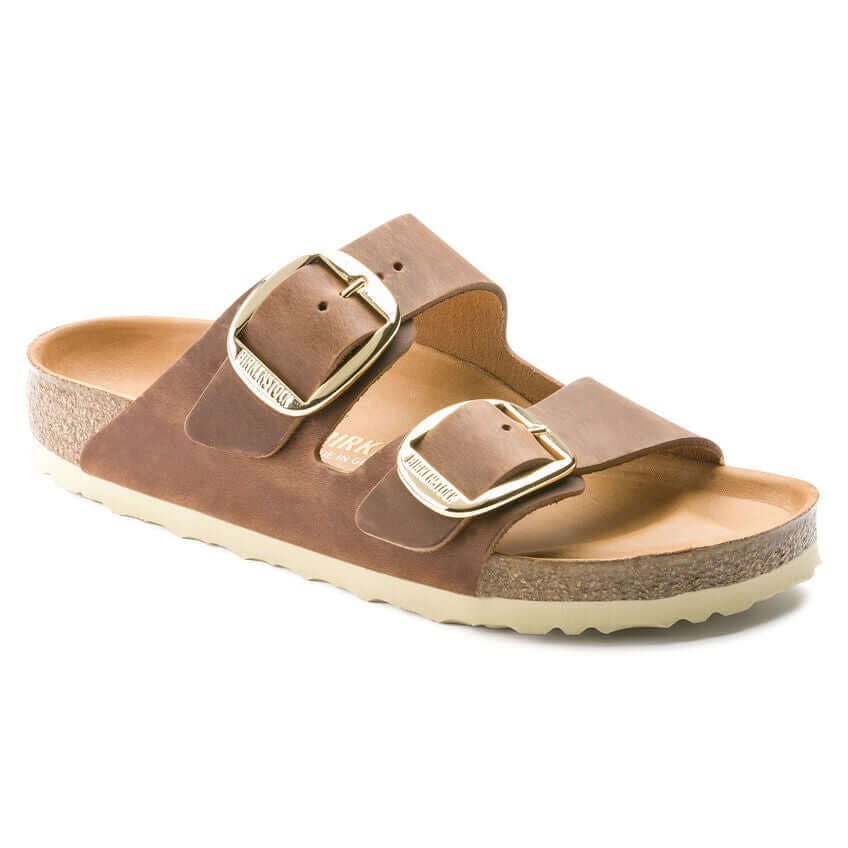 Brown slip-on sandals with dual gold buckles and a cork sole, perfect for casual summer wear.