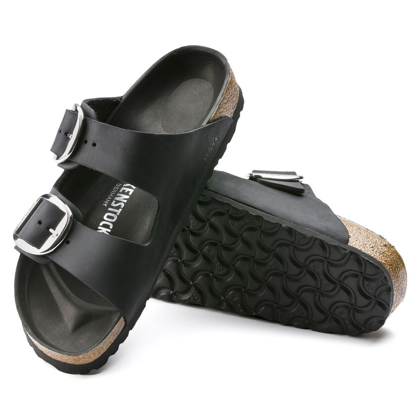 Black double-buckle leather sandals with textured soles.